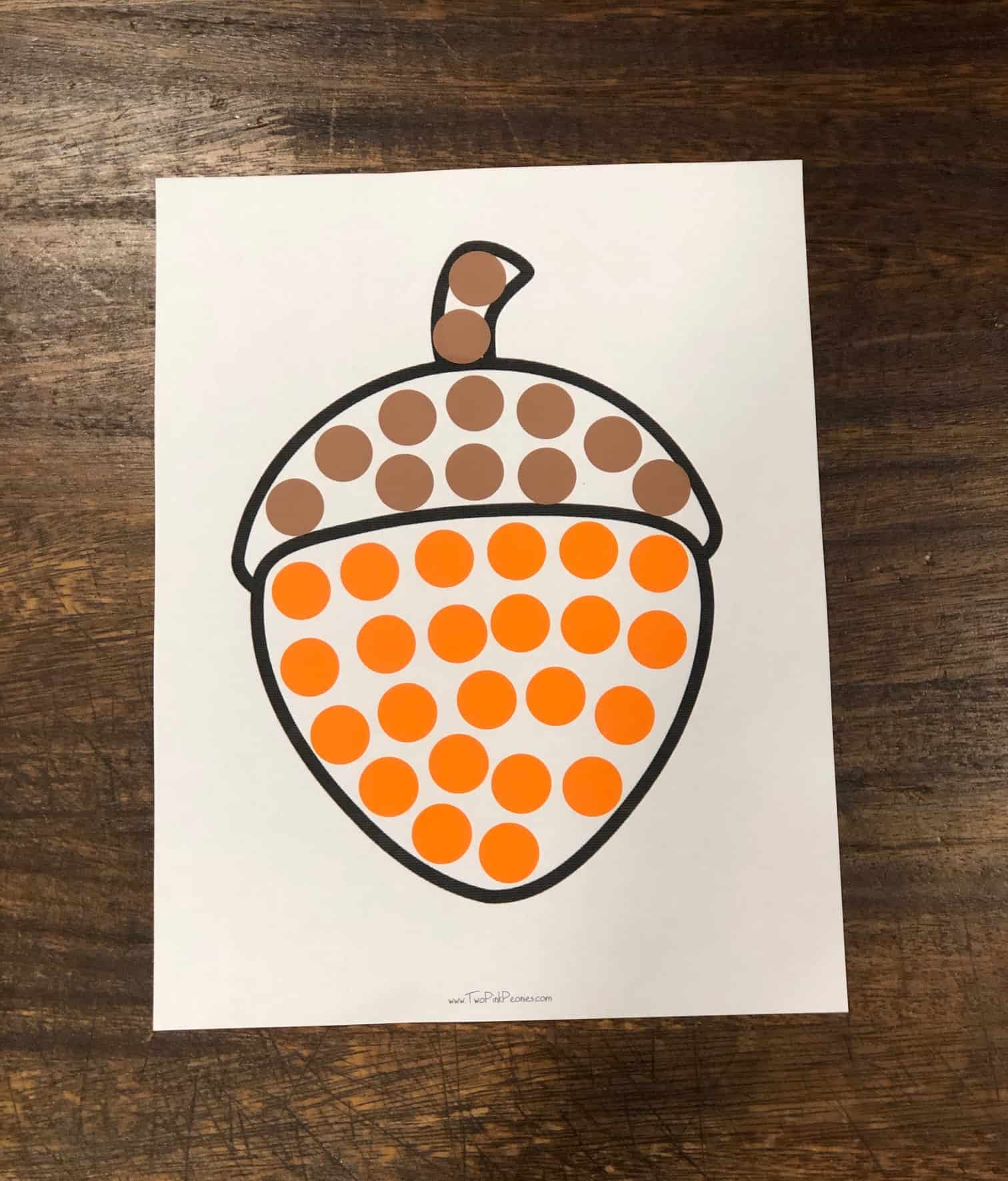 An acorn dot sticker printable with orange and brown dot stickers on it. 