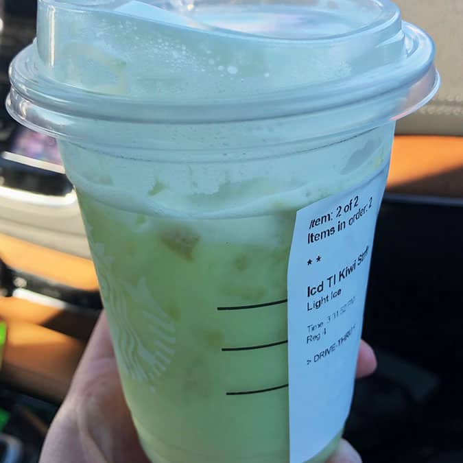 A iced drink from Starbucks being held by a hand. 