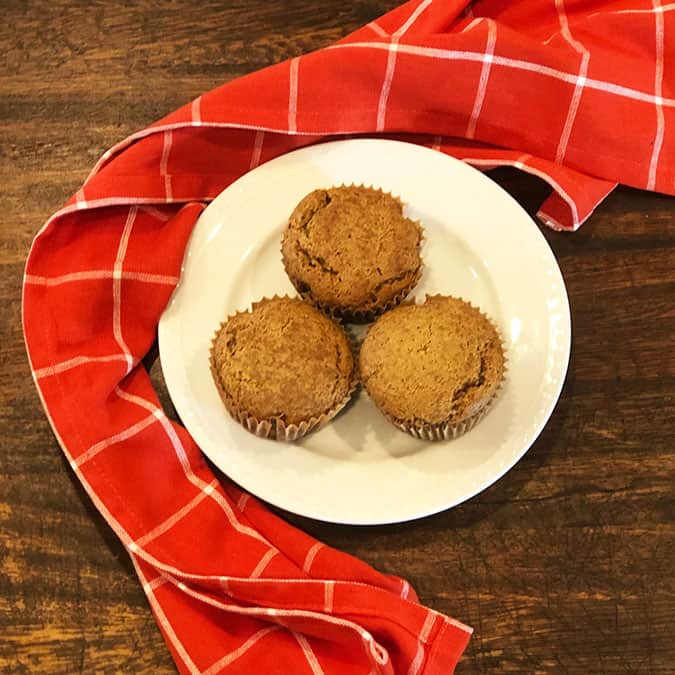 Prune muffins on a white plate with a red linen. 
