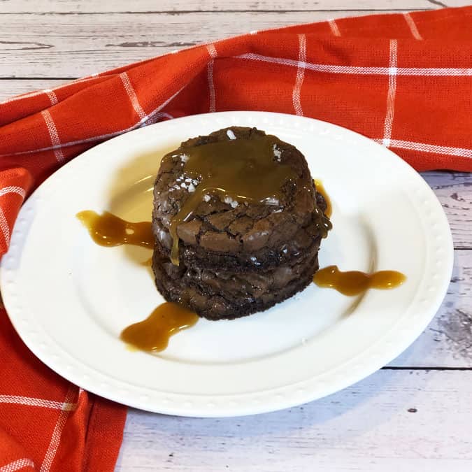 Salted Caramel Brownie Cookies with extra caramel sauce on a white plate. 