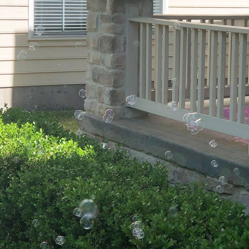 Bubbles floating around a front yard. 