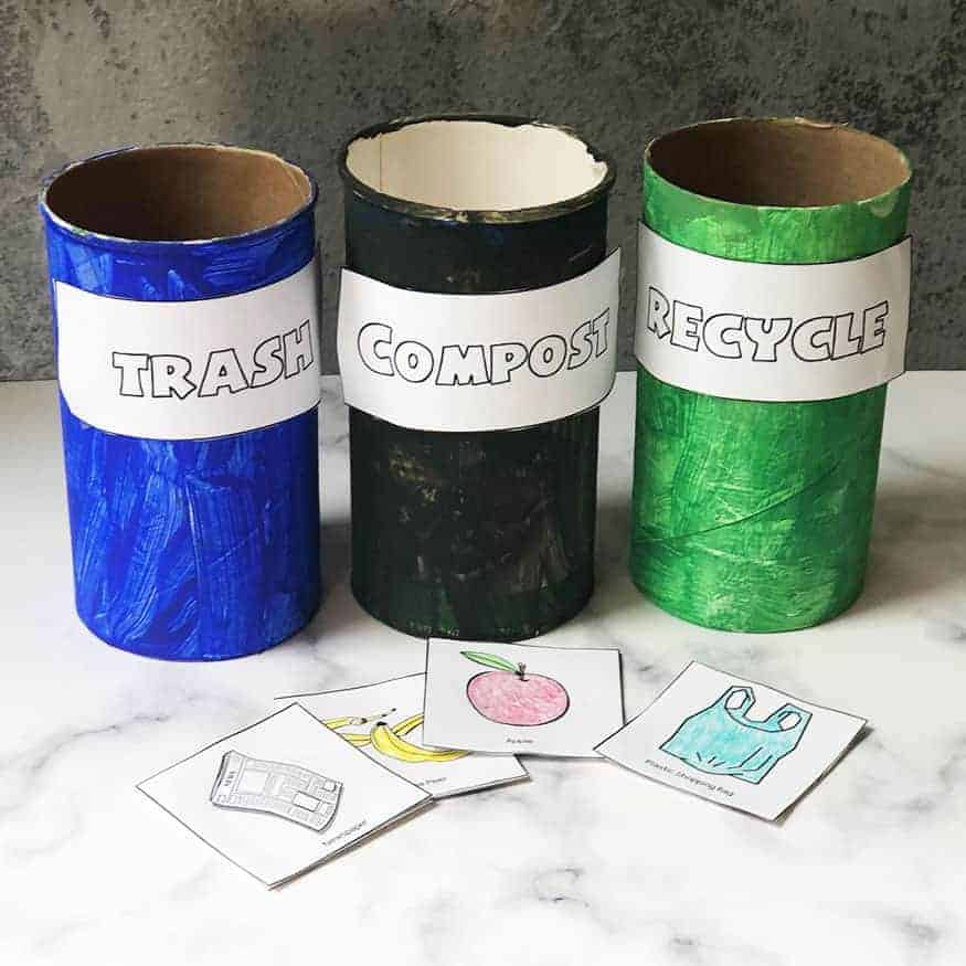 Recycling Activity for Preschoolers from recycled materials (empty oatmeal containers and cardboard). There are three containers labeled trash, compost, and recycle. 