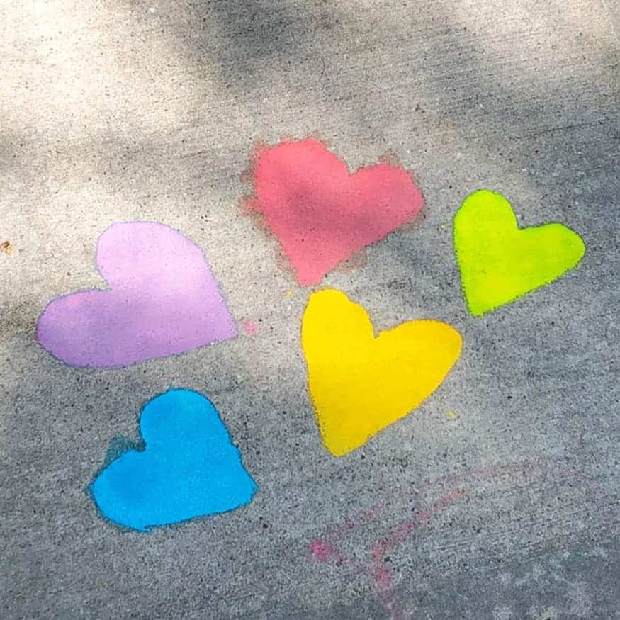Hearts of various colors painted with sidewalk chalk paint.