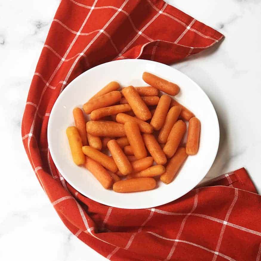 Copycat Cracker Barrel Carrots in a white bowl with a red linen. 