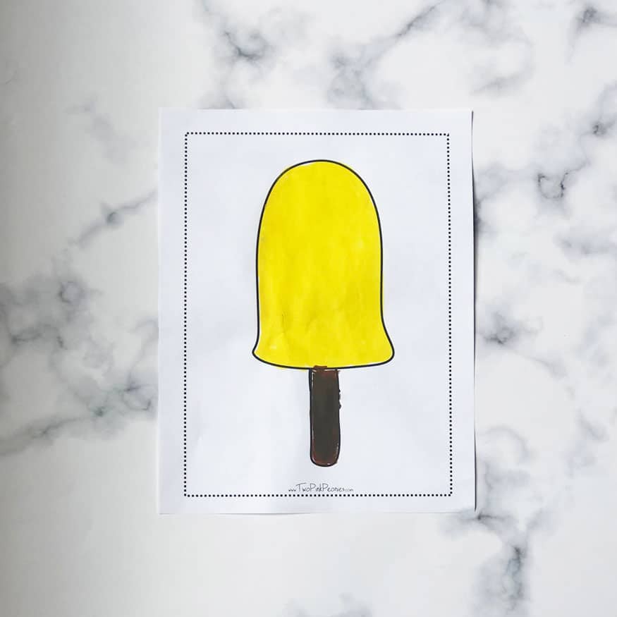 The popsicle template with yellow tempura paint on it. 