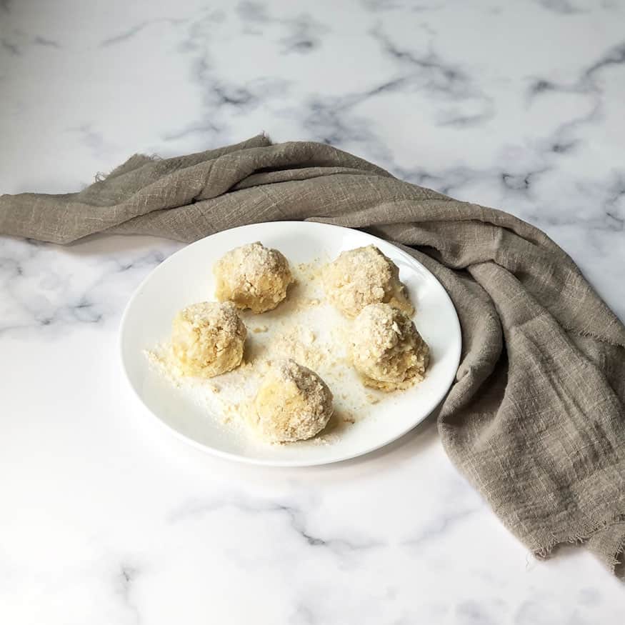 Banana Pudding Truffles on a white plate with a gray linen. 