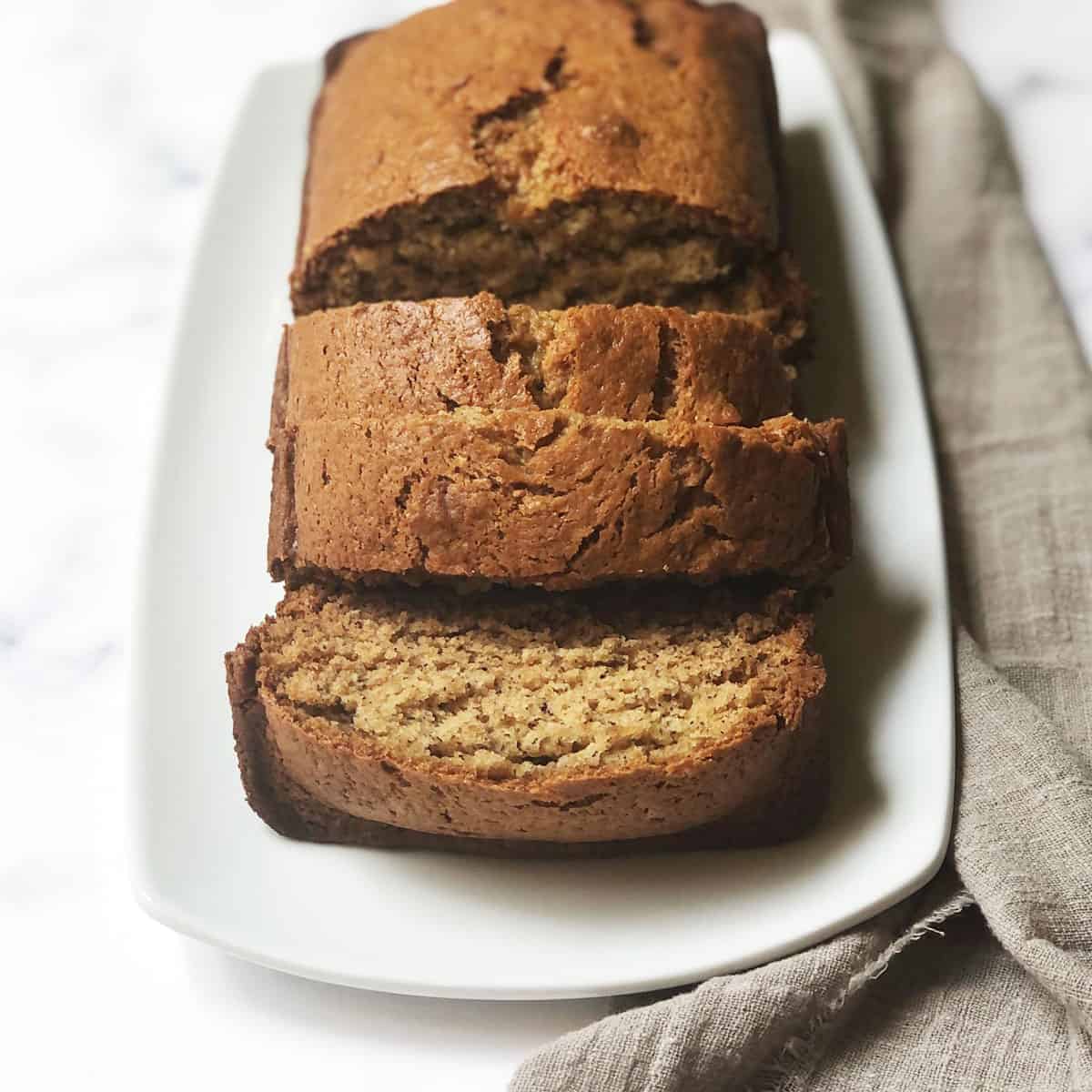 Copycat Starbucks Banana Bread loaf on a white rectangle plate. 