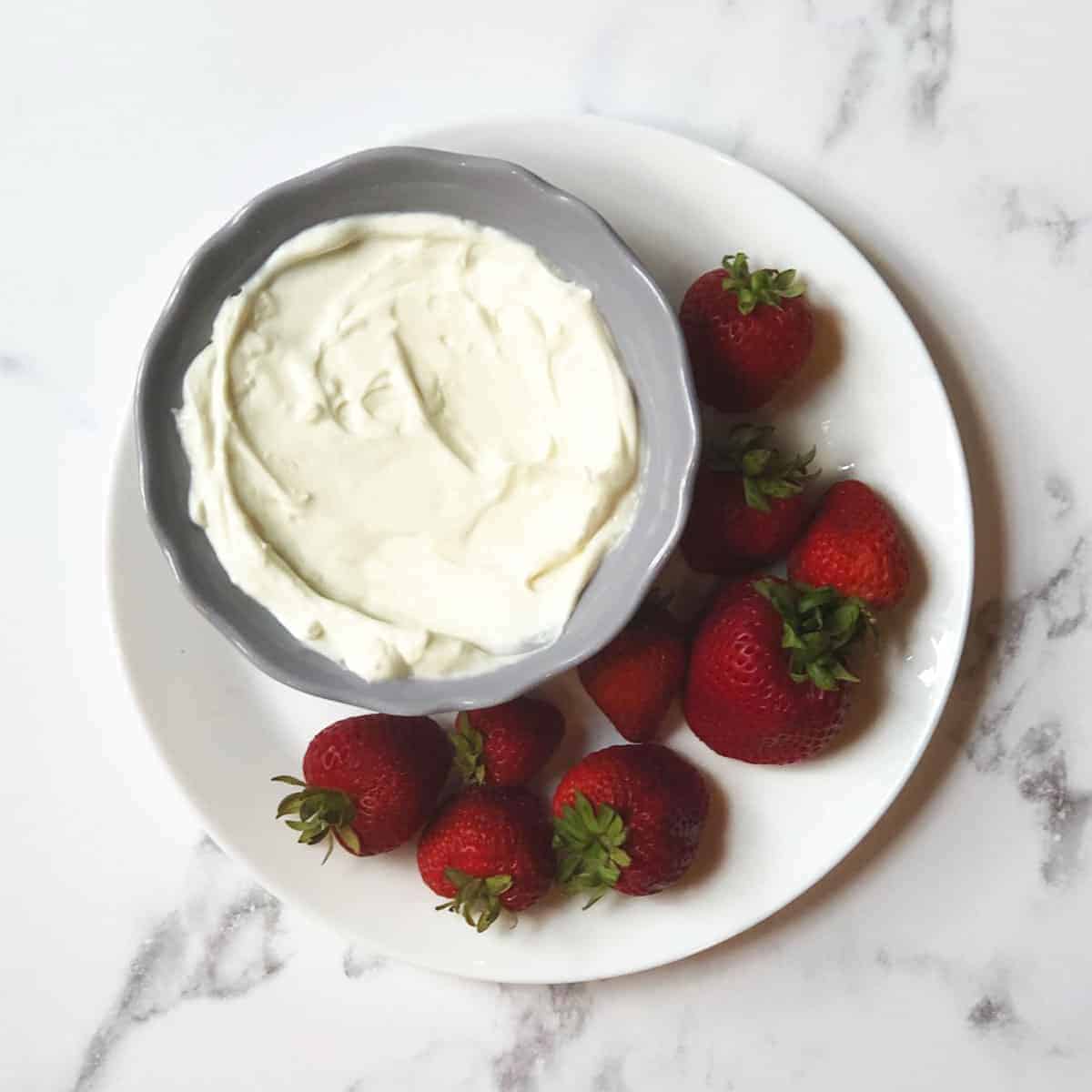 Copycat Jason's Deli Fruit Dip in a gray bowl surrounded by strawberries. 