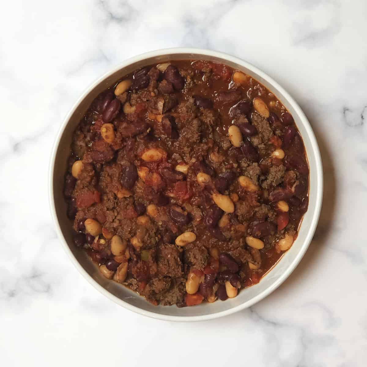 bison chili with beans in a white bowl 